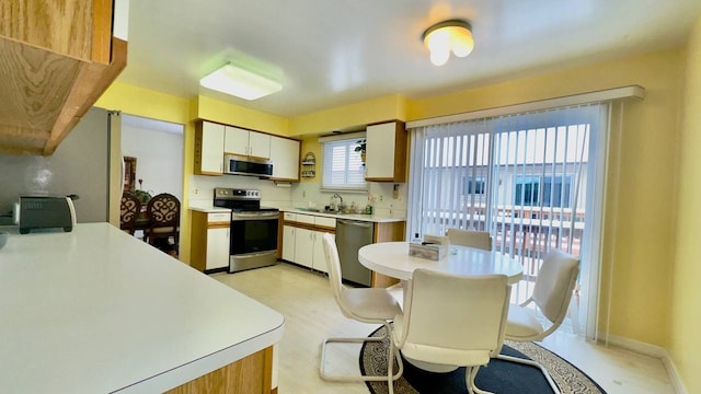 kitchen featuring stainless steel appliances, sink, and white cabinets