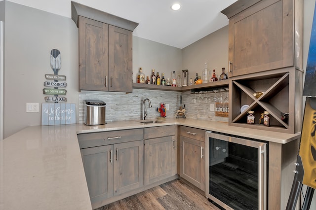 1611 Harwood Dr, Oxford, MI 48371 - indoor wet bar featuring wine cooler, tasteful backsplash, light wood finished floors, and recessed lighting