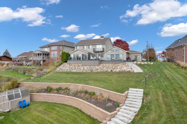 rear view of property with a balcony and a lawn