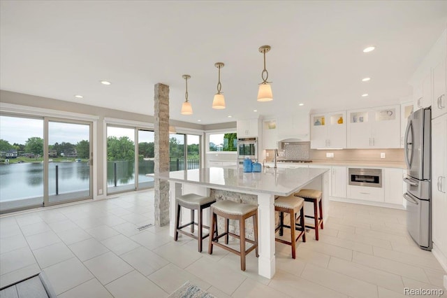 1611 Harwood Dr, Oxford, MI 48371 - kitchen with stainless steel appliances, recessed lighting, light tile patterned floors, a kitchen bar, and decorative backsplash