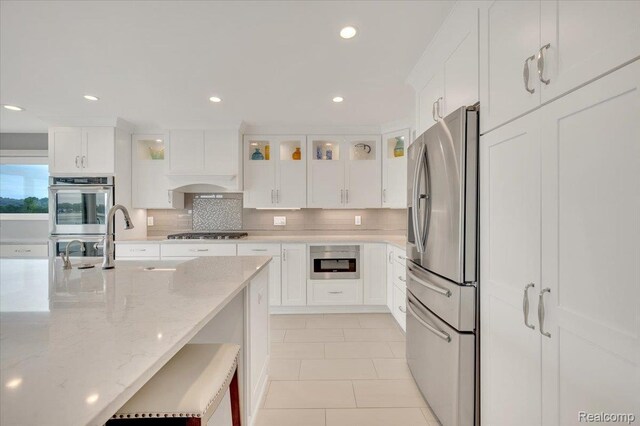 1611 Harwood Dr, Oxford, MI 48371 - kitchen with appliances with stainless steel finishes, white cabinets, glass insert cabinets, backsplash, and recessed lighting