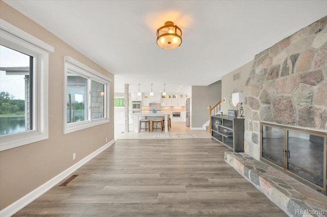 1611 Harwood Dr, Oxford, MI 48371 - living room featuring stairway, plenty of natural light, a fireplace, and wood finished floors