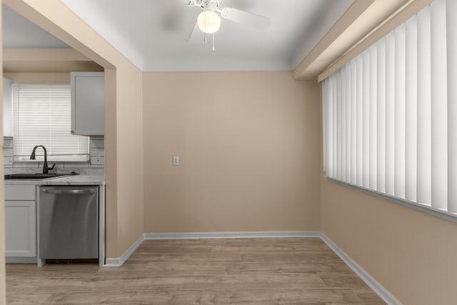 kitchen with ceiling fan, stainless steel dishwasher, sink, and light wood-type flooring