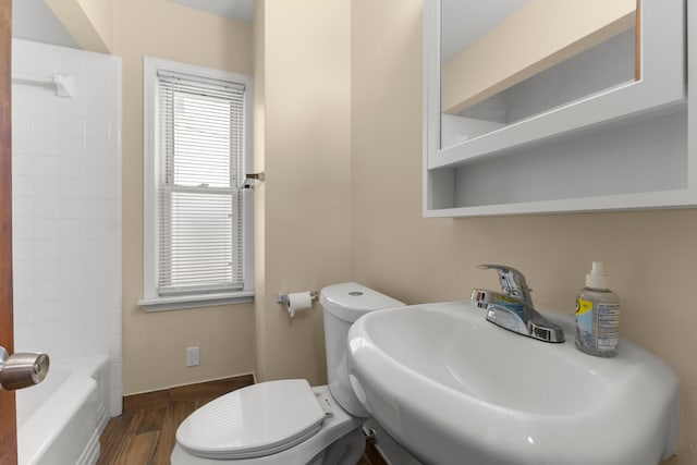 full bathroom with shower / bathing tub combination, sink, hardwood / wood-style floors, and toilet