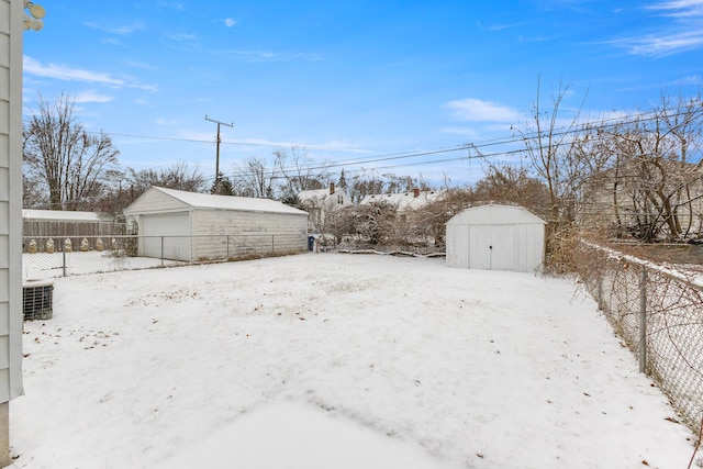 yard covered in snow featuring a storage shed