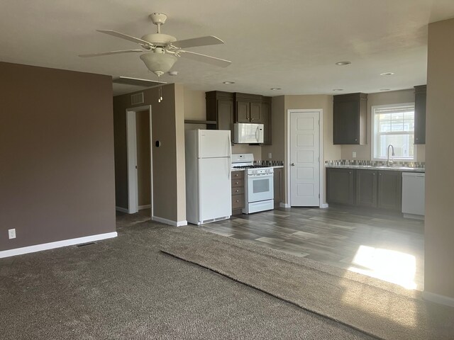 kitchen featuring dark brown cabinetry, ceiling fan, sink, and white appliances