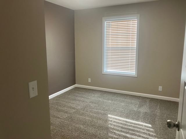 carpeted spare room with baseboards