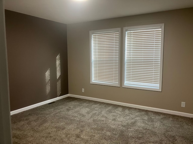 unfurnished room with carpet and baseboards