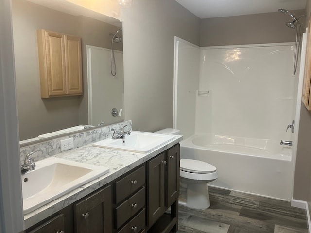 bathroom featuring double vanity, bathtub / shower combination, a sink, and toilet