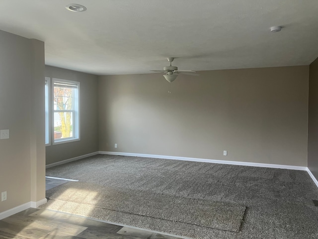 spare room featuring ceiling fan, baseboards, and light colored carpet