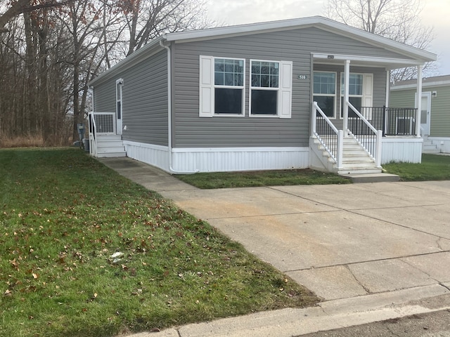 manufactured / mobile home featuring a front lawn and a porch