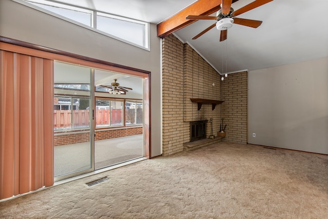 unfurnished living room featuring brick wall, beamed ceiling, carpet, ceiling fan, and a brick fireplace