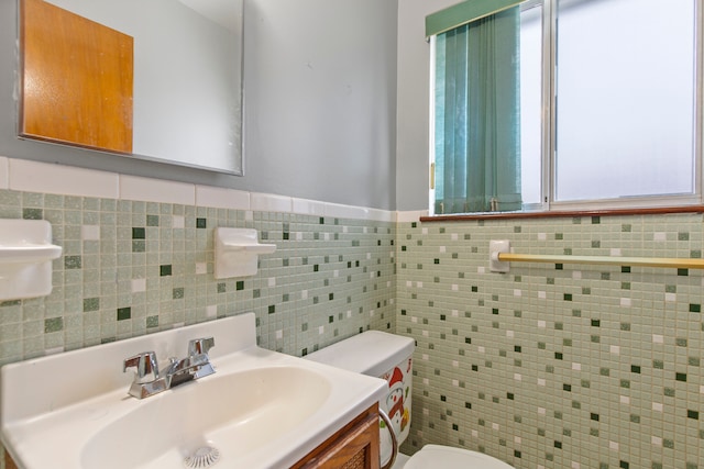 bathroom with vanity, tile walls, and toilet