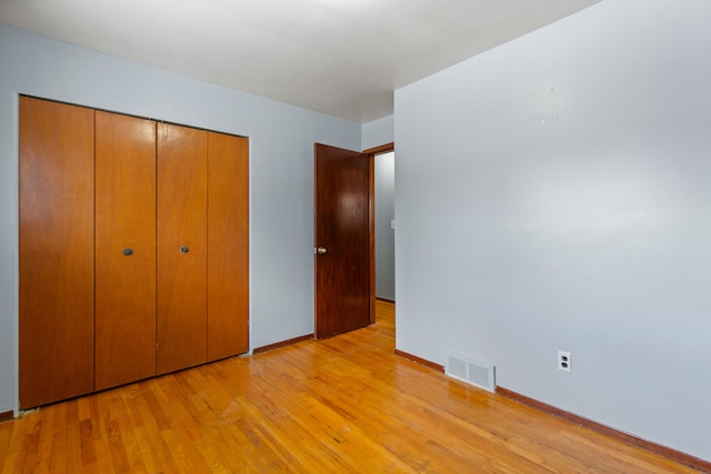 unfurnished bedroom with a closet and light wood-type flooring