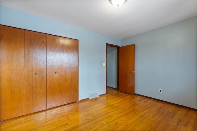 unfurnished bedroom featuring a closet and light wood-type flooring