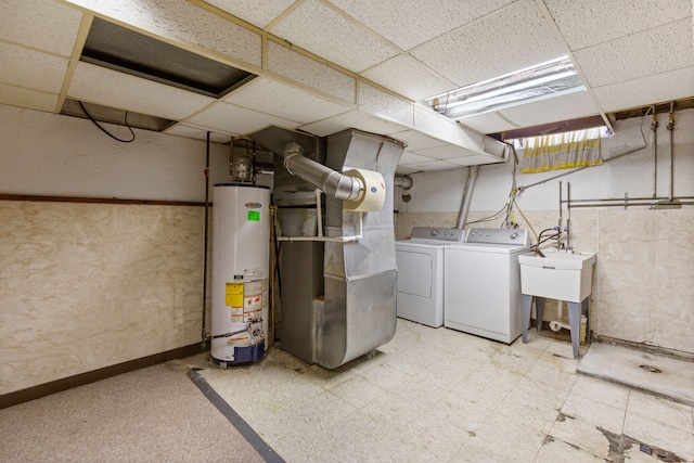 basement with independent washer and dryer, a drop ceiling, heating unit, and gas water heater