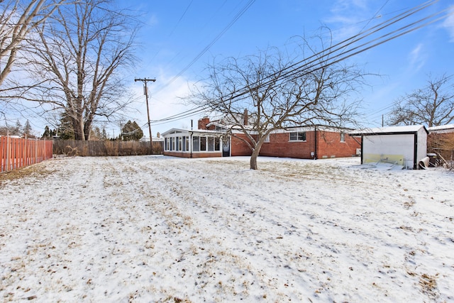 snowy yard with a sunroom