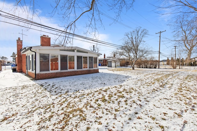 snow covered property with a sunroom