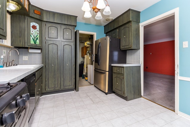 kitchen with a sink, an inviting chandelier, gas range oven, decorative backsplash, and stainless steel refrigerator with ice dispenser