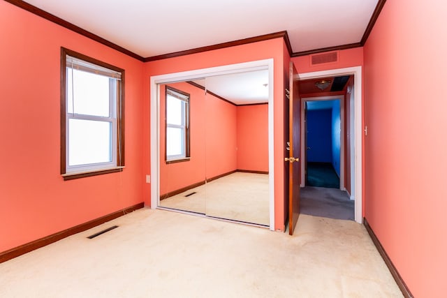 spare room with visible vents, light carpet, and crown molding