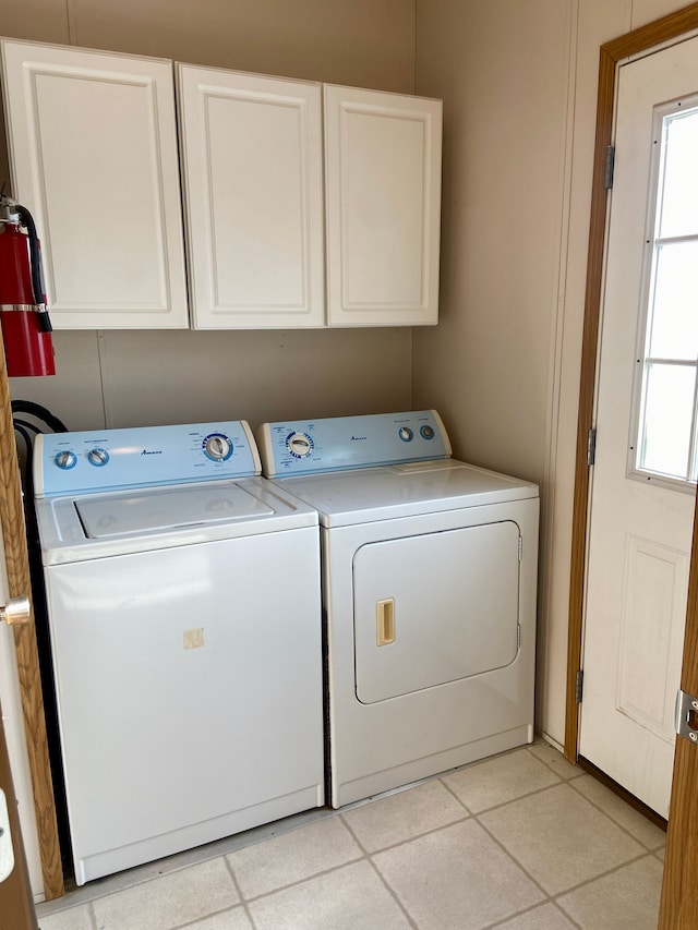 laundry area with cabinets and washing machine and clothes dryer