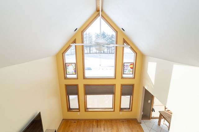 additional living space with light hardwood / wood-style floors and vaulted ceiling with beams