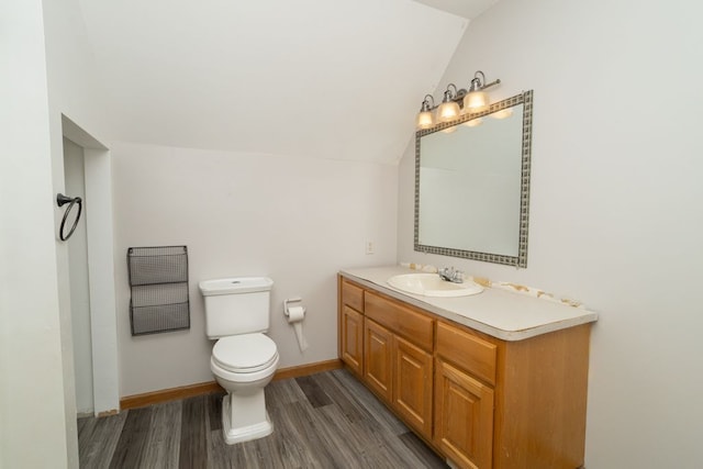 bathroom featuring vanity, lofted ceiling, hardwood / wood-style floors, and toilet