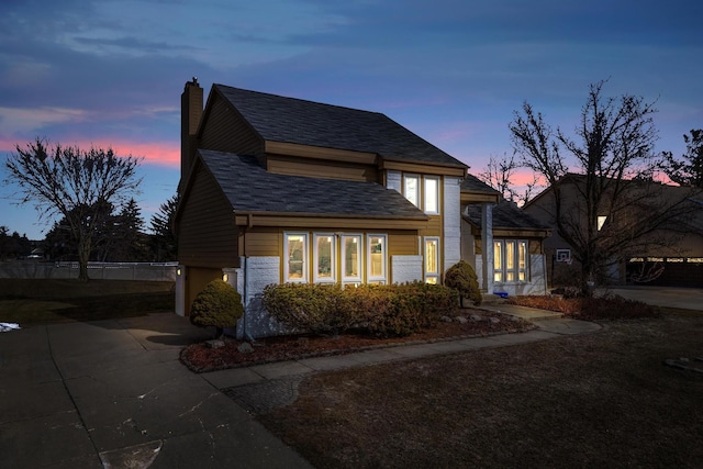 view of front of property featuring fence, driveway, a shingled roof, a chimney, and a garage