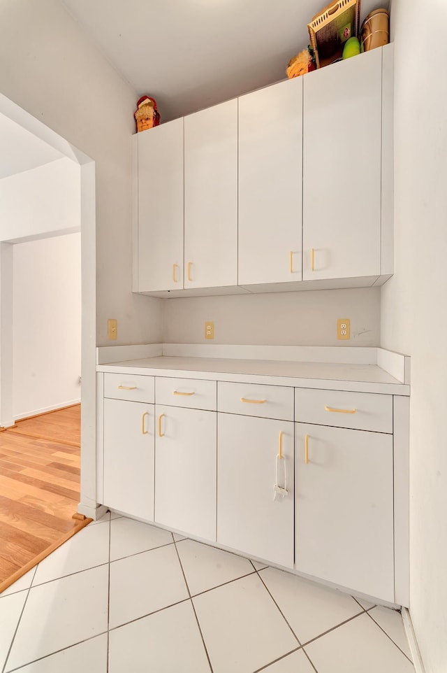 kitchen with light countertops, white cabinets, and light tile patterned flooring