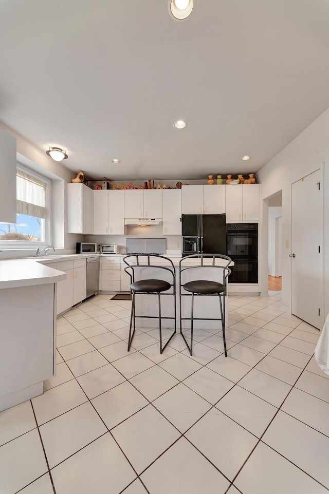 kitchen with light tile patterned floors, stainless steel dishwasher, black refrigerator with ice dispenser, and white cabinetry