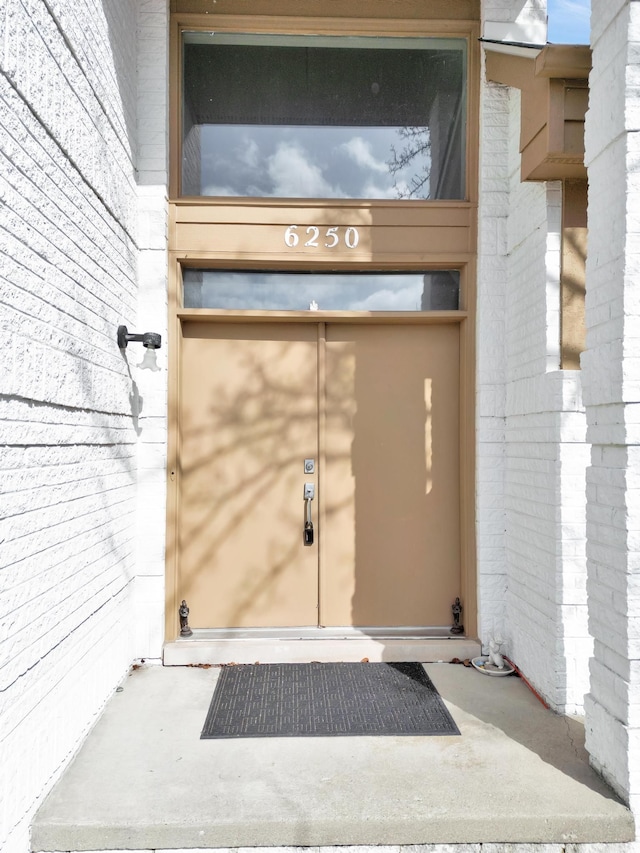 doorway to property with brick siding