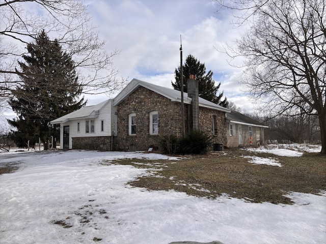 snow covered property featuring central AC