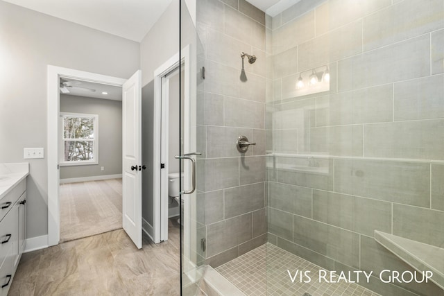 bathroom featuring a shower stall, baseboards, vanity, and toilet
