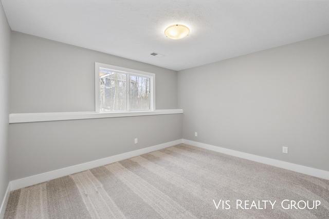 empty room featuring carpet floors, baseboards, and visible vents
