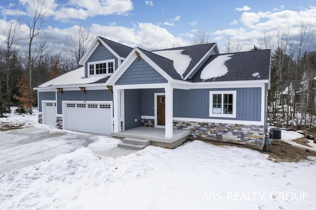 view of front of property featuring a garage and stone siding