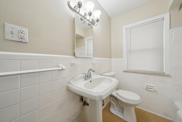 bathroom featuring toilet, tile patterned flooring, and tile walls