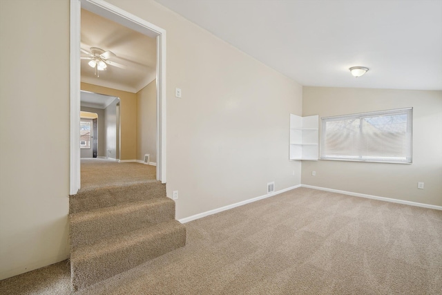 carpeted spare room featuring lofted ceiling and ceiling fan