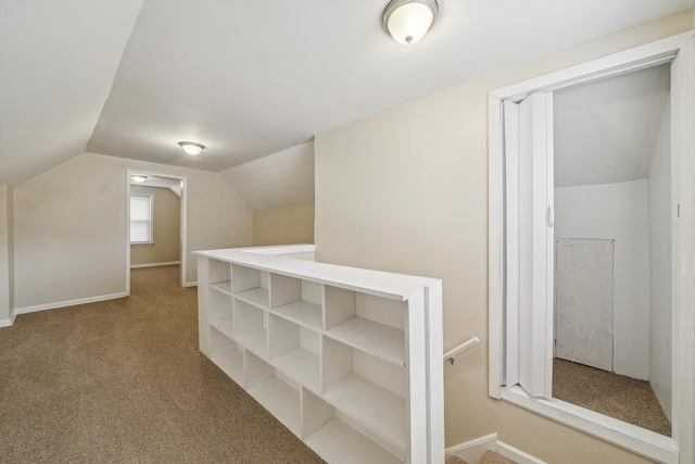 hallway featuring vaulted ceiling and carpet floors