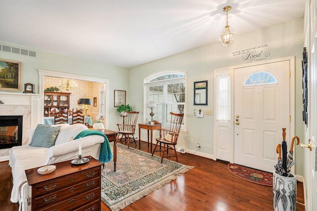 foyer entrance featuring a high end fireplace and dark hardwood / wood-style flooring