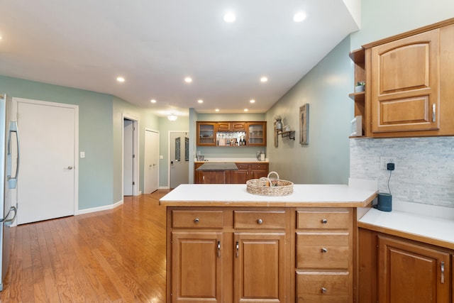 kitchen with tasteful backsplash, light hardwood / wood-style floors, and kitchen peninsula