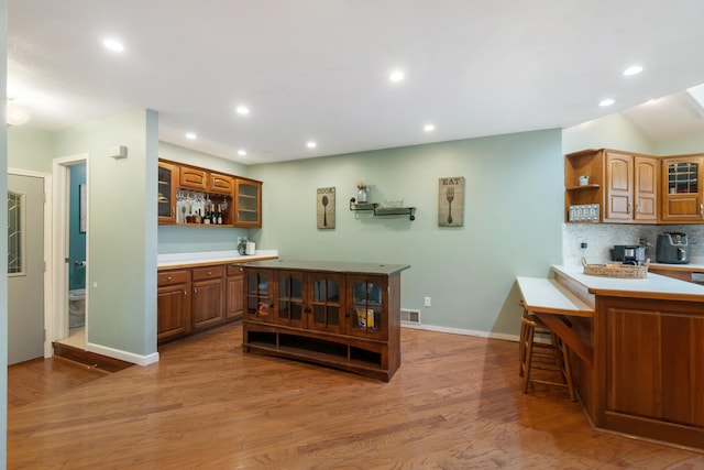 kitchen featuring tasteful backsplash, wood-type flooring, and a breakfast bar area