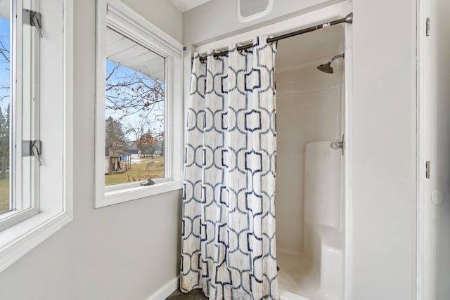 bathroom featuring a shower with shower curtain and a wealth of natural light