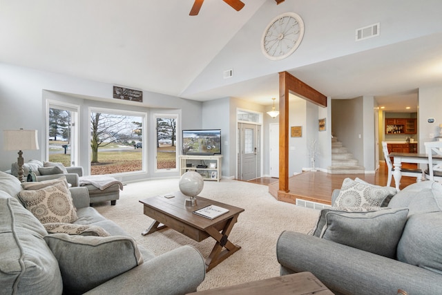 living room featuring light wood-type flooring and high vaulted ceiling