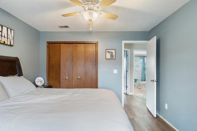 bedroom with hardwood / wood-style flooring, ceiling fan, and a closet