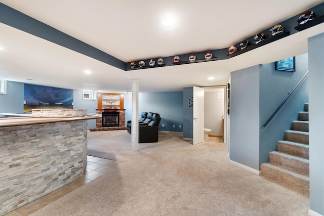 living room featuring a brick fireplace and light tile patterned floors