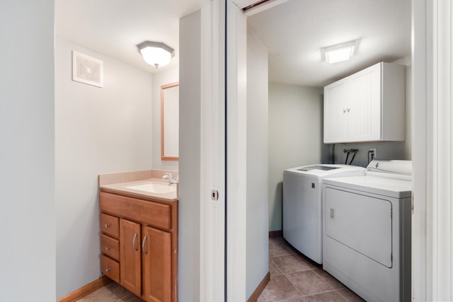 laundry area featuring cabinets, separate washer and dryer, sink, and light tile patterned floors