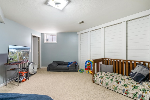 bedroom with carpet floors and a textured ceiling