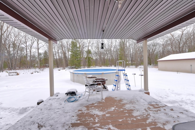 snow covered patio with a swimming pool side deck