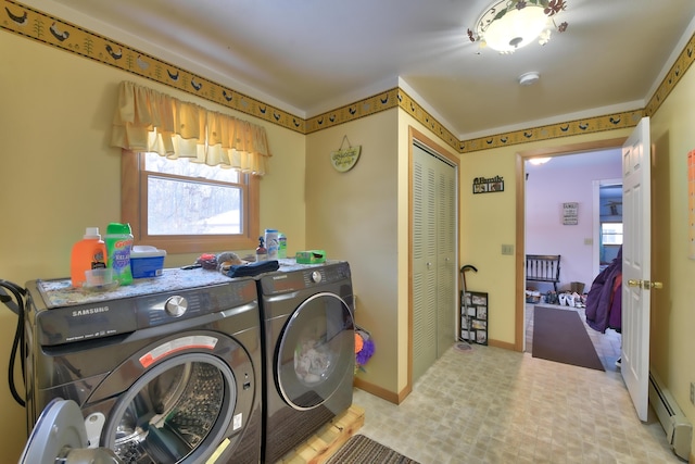 washroom with a baseboard radiator and washer and clothes dryer