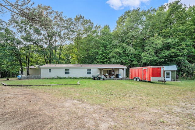 back of house with a lawn and an outdoor structure